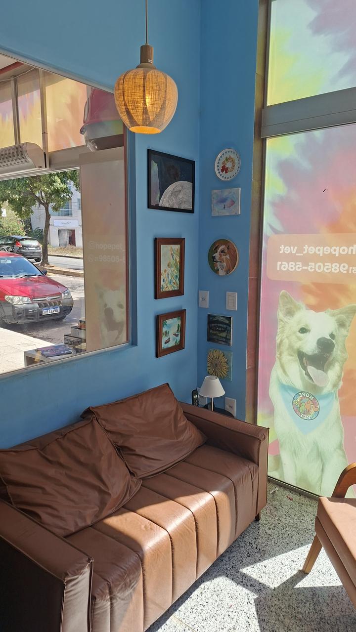 Sala de espera com sofá e mural tie-dye
